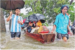 নৌকায় করে নিরাপদ আশ্রয়ের খোঁজে একটি পরিবার। গতকাল ফেনীতে-ছবি: এএফপি